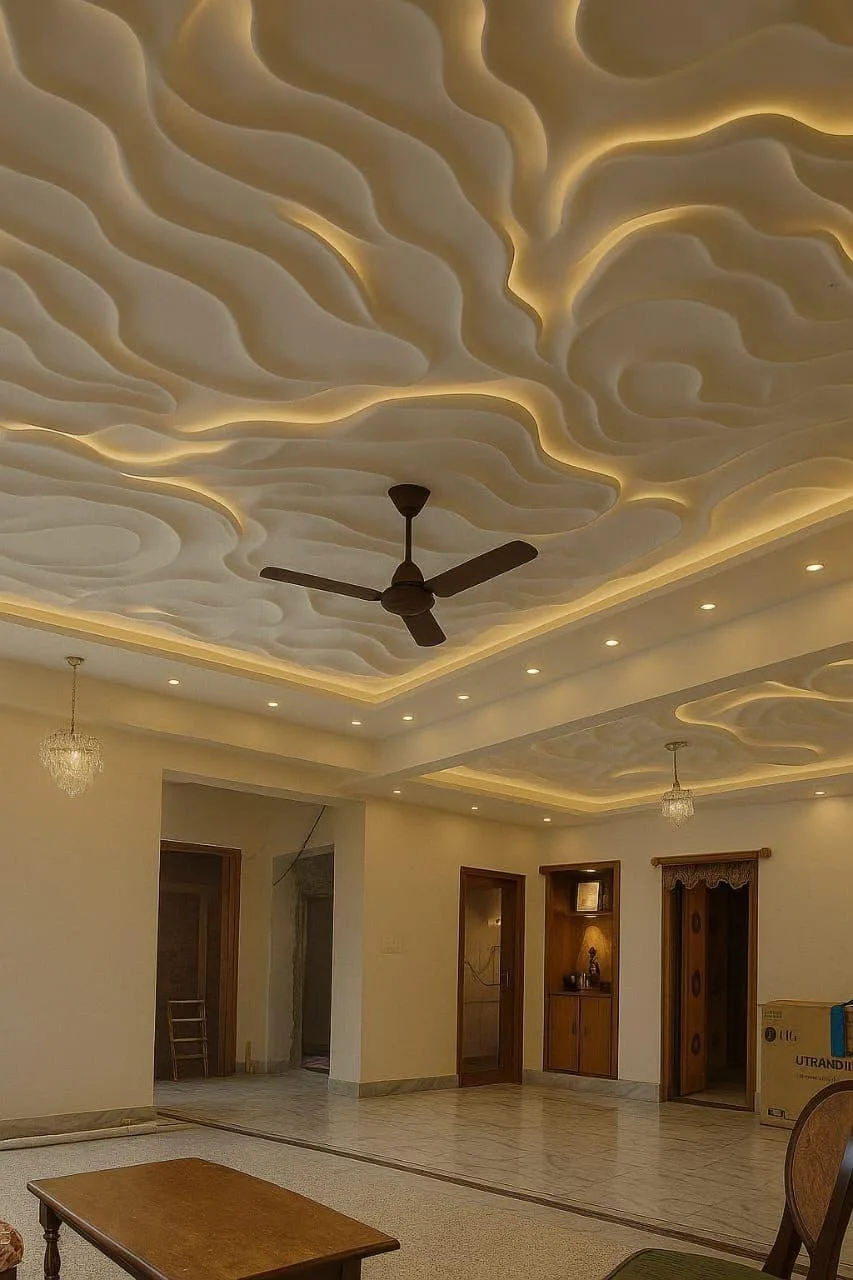 A hall with a sculpted false ceiling, a warm cove border, a row of downlights and a ceiling fan