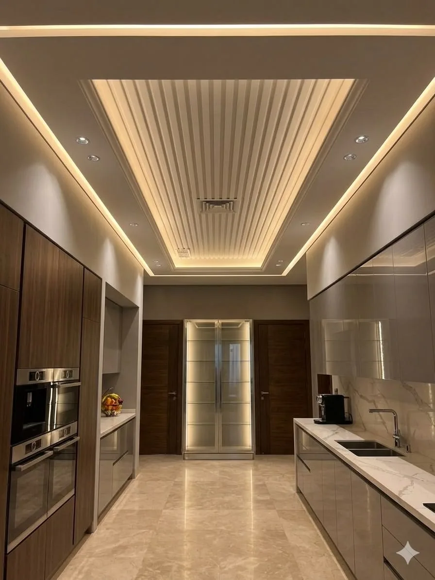 A kitchen with a fluted false ceiling, cove lighting and tall cabinets